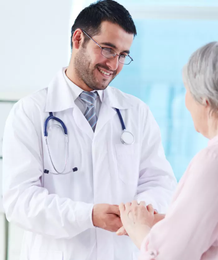 Desk with leather desk pad, walnut desk organizer, wireless keyboard and mouse, and porcelain mug.